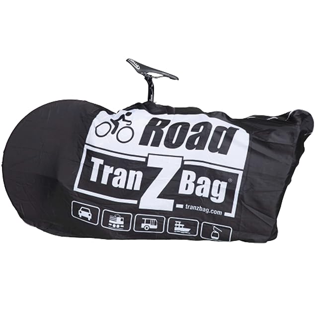 Housse EVOC TranZbag ROAD repliée dans son propre petit sac, à côté d'un vélo de route